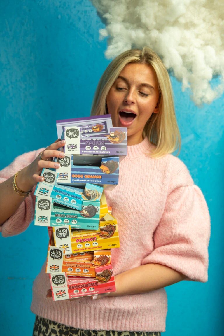 woman holding a stack of yubi bar protein bars